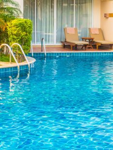 Empty Umbrella and chair around swimming pool in hotel resort