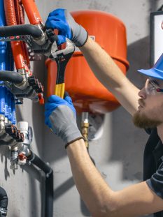man-installs-heating-system-house-checks-pipes-with-wrench