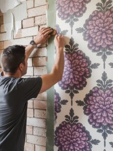 worker-install-wallpaper-wall-home-restoration-concept-man-glues-wallpaper-wall-vertical